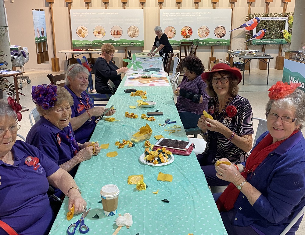 Group of women with red hats sitting around table